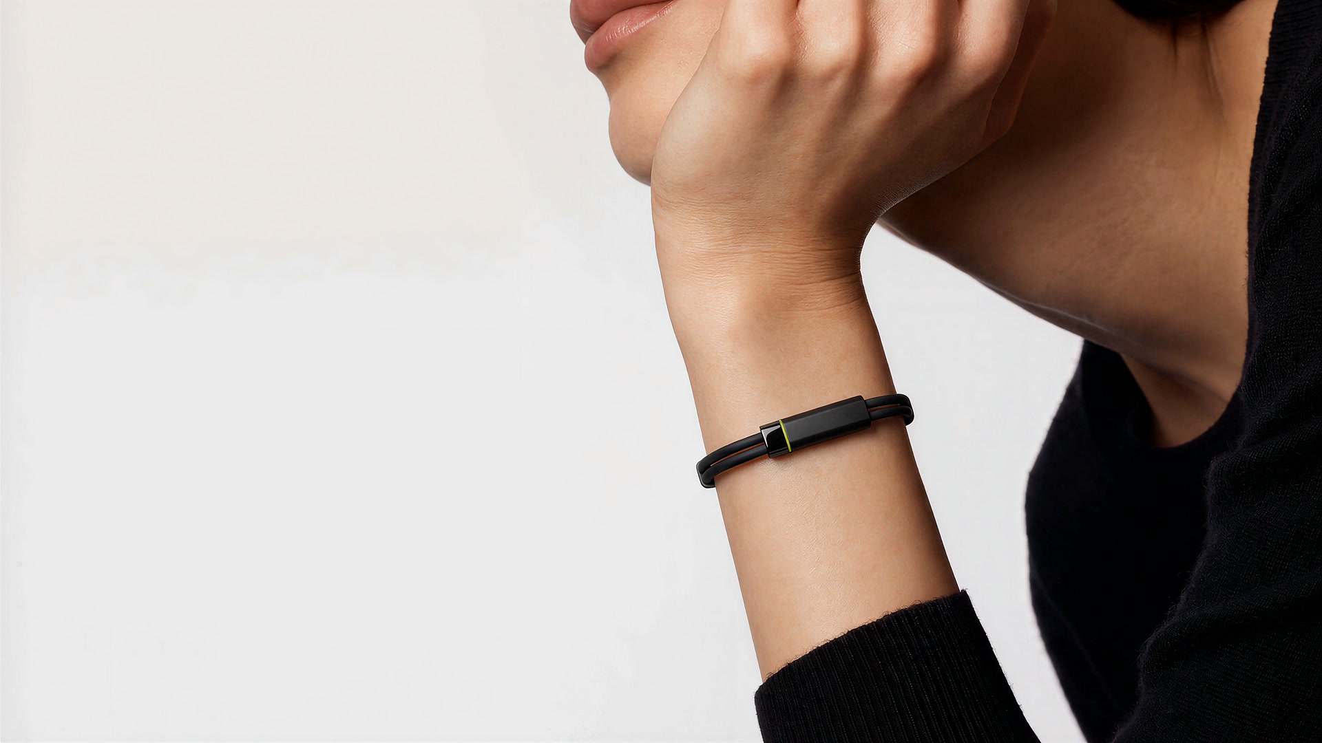 The Larkin band on a woman's wrist, its lime light on, as she rests her chin on her hand