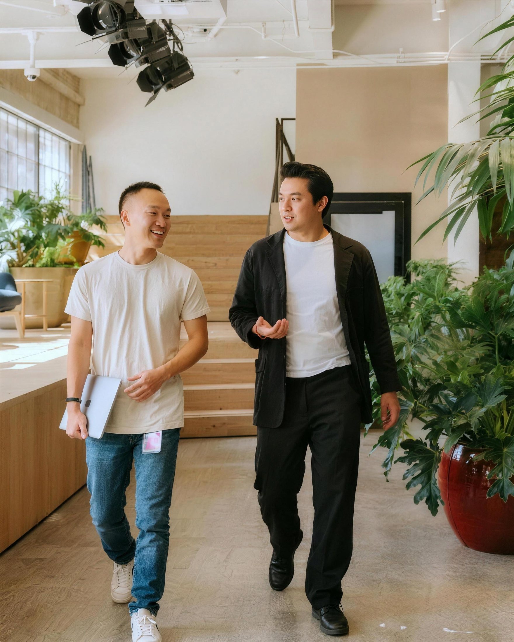 Two colleagues walking and talking through a bright office
